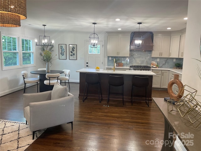 5840 Charing Pl, Charlotte, NC 28211 - kitchen with premium range hood, a chandelier, light countertops, decorative backsplash, and dark wood-style flooring
