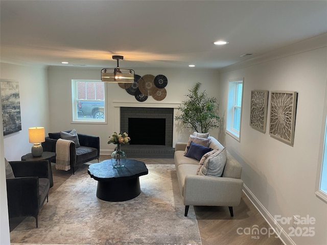5840 Charing Pl, Charlotte, NC 28211 - living area with plenty of natural light, a brick fireplace, wood finished floors, recessed lighting, and ornamental molding