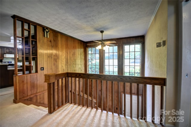 41 Balsam Shadows Rd, Maggie Valley, NC 28751 - stairs featuring ornamental molding, wood walls, a textured ceiling, ceiling fan, and carpet floors