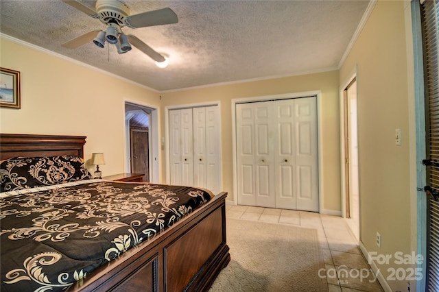 41 Balsam Shadows Rd, Maggie Valley, NC 28751 - bedroom featuring light tile patterned flooring, multiple closets, a textured ceiling, baseboards, and a ceiling fan