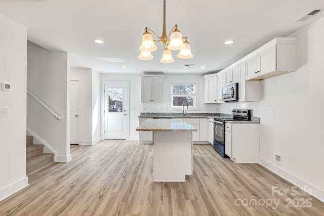 81 Kirk St, Salisbury, NC 28144 - kitchen featuring appliances with stainless steel finishes, a sink, light wood-style floors, baseboards, and a chandelier