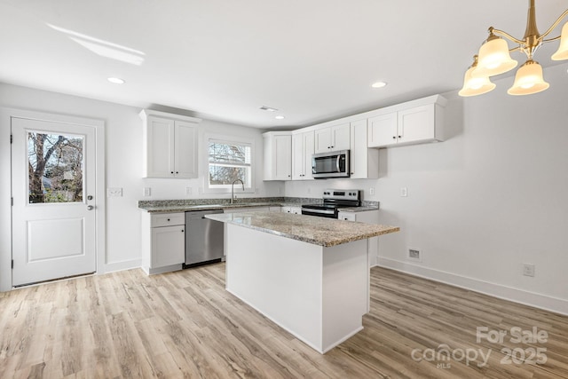 81 Kirk St, Salisbury, NC 28144 - kitchen with stainless steel appliances, baseboards, light wood-style floors, white cabinets, and recessed lighting