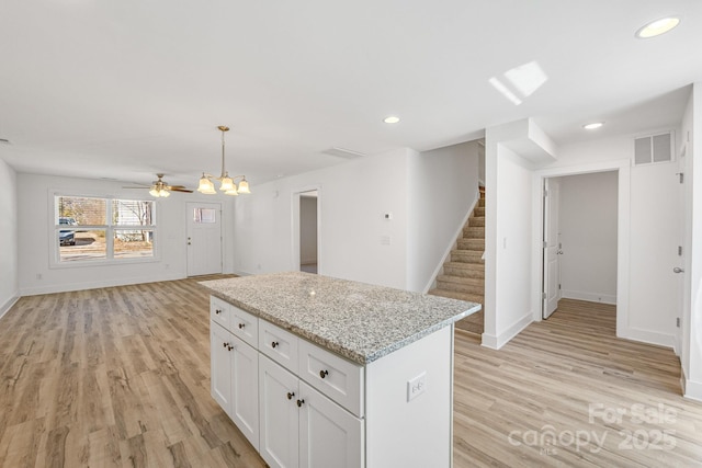 81 Kirk St, Salisbury, NC 28144 - kitchen featuring a center island, light wood-style flooring, white cabinetry, open floor plan, and hanging light fixtures