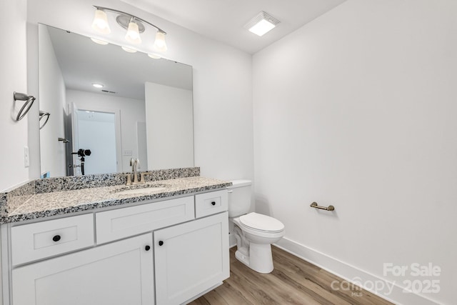 81 Kirk St, Salisbury, NC 28144 - bathroom featuring baseboards, wood finished floors, toilet, and vanity