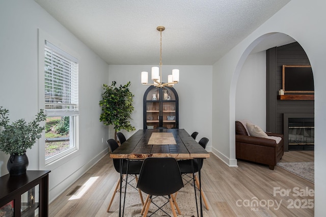 1256 Canseco Ln, Hickory, NC 28602 - dining area featuring a chandelier, light wood-style floors, healthy amount of natural light, a large fireplace, and a textured ceiling