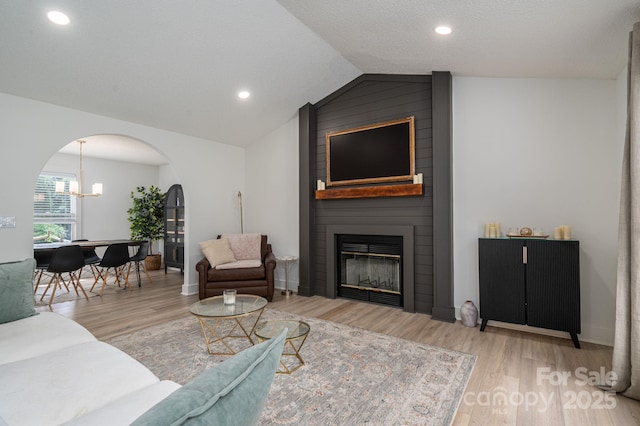 1256 Canseco Ln, Hickory, NC 28602 - living area with arched walkways, wood finished floors, lofted ceiling, a large fireplace, and a chandelier