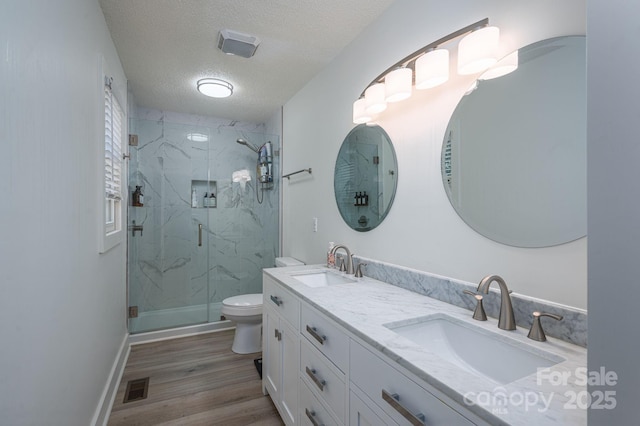 1256 Canseco Ln, Hickory, NC 28602 - bathroom featuring a marble finish shower, a textured ceiling, double vanity, and wood finished floors