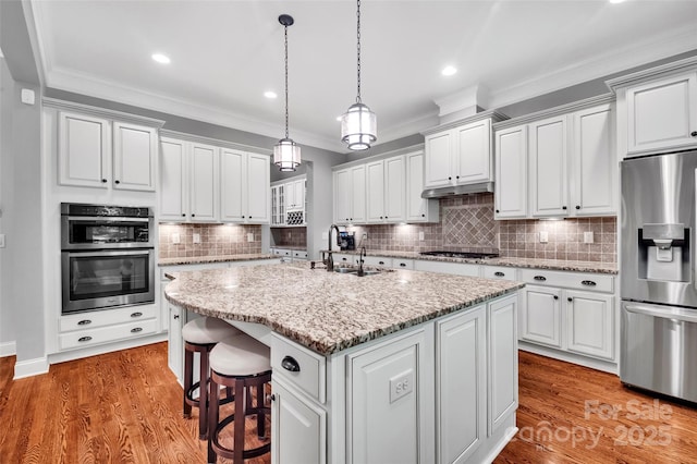 1600 Buckland Ct, Indian Land, SC 29707 - kitchen with appliances with stainless steel finishes, ornamental molding, an island with sink, white cabinets, and pendant lighting