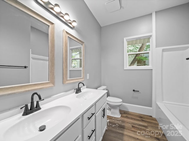 144 Walnut St, Chester, SC 29706 - full bath with wood finished floors, double vanity, and plenty of natural light