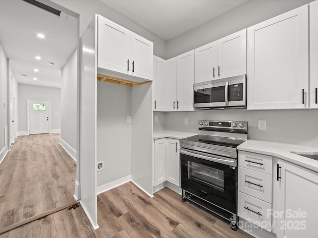 144 Walnut St, Chester, SC 29706 - kitchen with stainless steel appliances, wood finished floors, white cabinetry, recessed lighting, and light countertops
