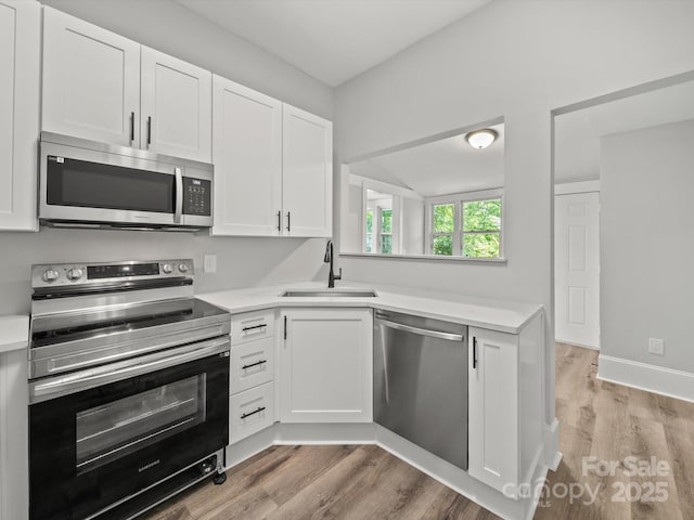 144 Walnut St, Chester, SC 29706 - kitchen featuring stainless steel appliances, light countertops, white cabinets, light wood-type flooring, and lofted ceiling