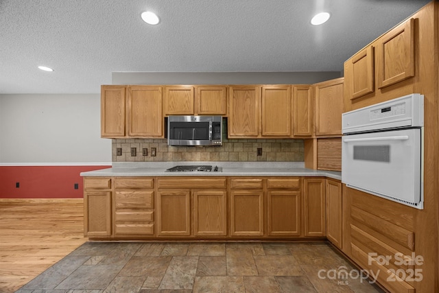 449 Concord Rd, Fletcher, NC 28732 - kitchen with white oven, stainless steel microwave, gas cooktop, light countertops, and a textured ceiling