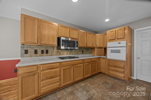 449 Concord Rd, Fletcher, NC 28732 - kitchen with stainless steel appliances, light countertops, decorative backsplash, a textured ceiling, and baseboards