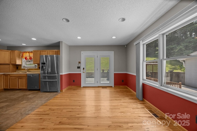 449 Concord Rd, Fletcher, NC 28732 - kitchen with stainless steel fridge with ice dispenser, dishwasher, plenty of natural light, a textured ceiling, and light wood finished floors