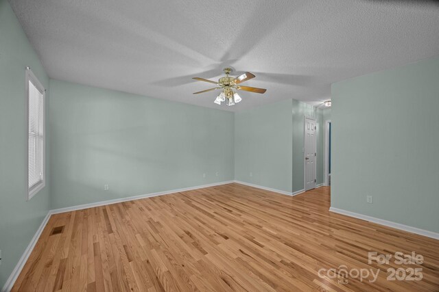449 Concord Rd, Fletcher, NC 28732 - spare room featuring a textured ceiling, light wood finished floors, a ceiling fan, and baseboards