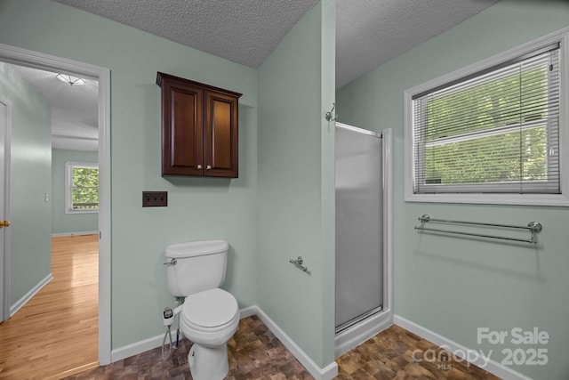 449 Concord Rd, Fletcher, NC 28732 - bathroom featuring a shower stall, a textured ceiling, toilet, baseboards, and wood finished floors