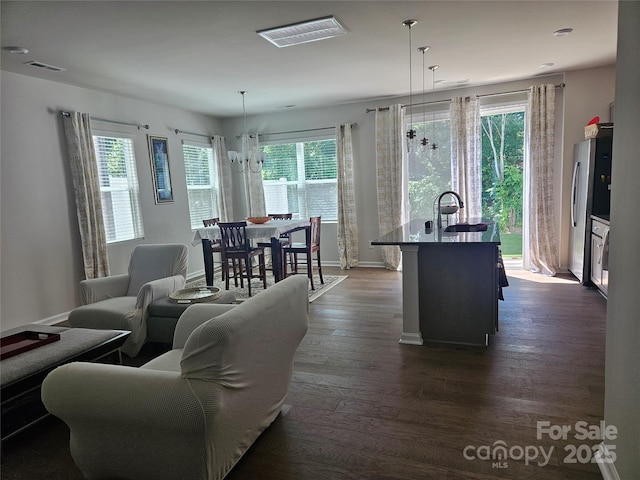 9142 Widden Way, Charlotte, NC 28269 - living room featuring baseboards, dark wood-type flooring, and a chandelier