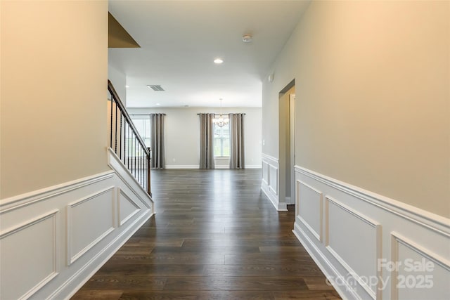 174 Pine Eagle Dr, Rock Hill, SC 29732 - hall featuring a chandelier, a decorative wall, wainscoting, stairway, and dark wood-style floors