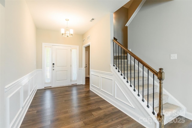 174 Pine Eagle Dr, Rock Hill, SC 29732 - foyer with a chandelier, stairs, a wainscoted wall, a decorative wall, and dark wood-style flooring