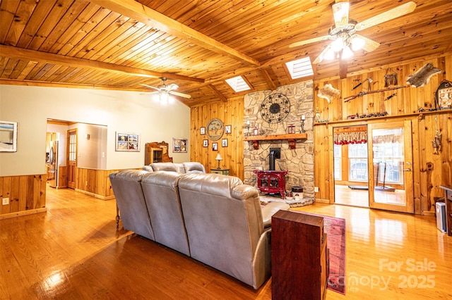 377 Birch Circle Dr, Hudson, NC 28638 - living room featuring a ceiling fan, wooden ceiling, wooden walls, a wood stove, and wood finished floors