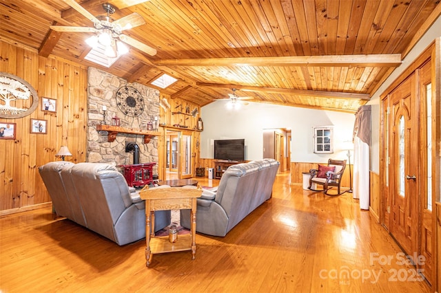 377 Birch Circle Dr, Hudson, NC 28638 - living room featuring ceiling fan, wood ceiling, a wood stove, light wood-style floors, and wood walls