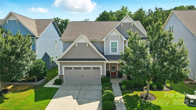 2246 Bluebell Way, Tega Cay, SC 29708 - craftsman-style house with concrete driveway, a front yard, a garage, a shingled roof, and stone siding