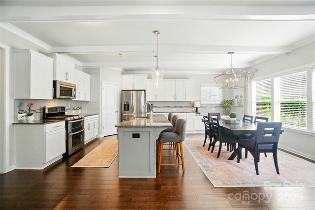 2246 Bluebell Way, Tega Cay, SC 29708 - kitchen featuring stainless steel appliances, beam ceiling, a kitchen breakfast bar, dark wood-type flooring, and white cabinets