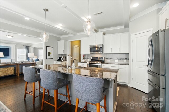 2246 Bluebell Way, Tega Cay, SC 29708 - kitchen featuring stainless steel appliances, a sink, ornamental molding, a breakfast bar area, and dark wood-style floors