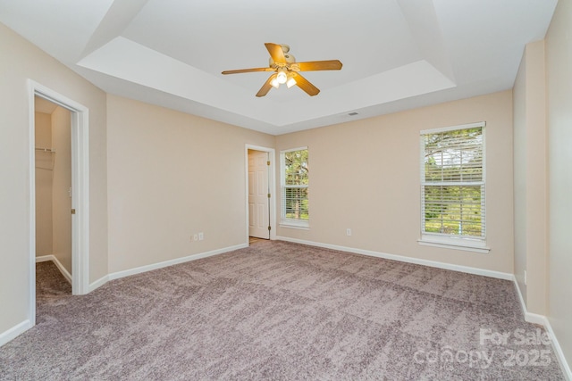 5322 Jocelyn Ln, Charlotte, NC 28269 - carpeted empty room with a raised ceiling, healthy amount of natural light, ceiling fan, and baseboards