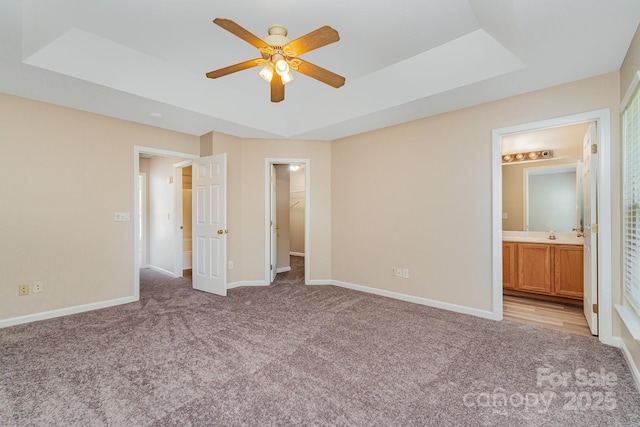 5322 Jocelyn Ln, Charlotte, NC 28269 - unfurnished bedroom with a raised ceiling, light carpet, baseboards, and a walk in closet