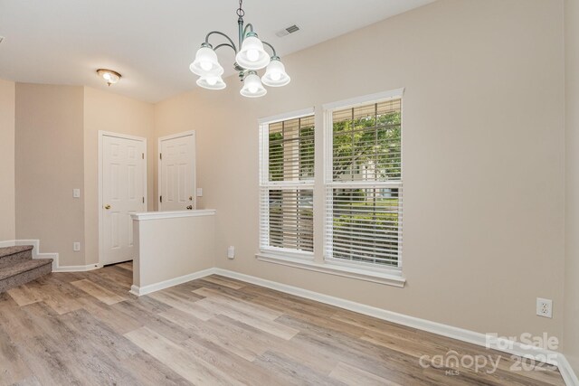 5322 Jocelyn Ln, Charlotte, NC 28269 - empty room with light wood-style flooring, a chandelier, stairway, and baseboards