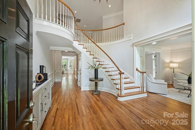 7319 Stonehaven Dr, Waxhaw, NC 28173 - entrance foyer with stairs, ornamental molding, wood finished floors, a high ceiling, and baseboards
