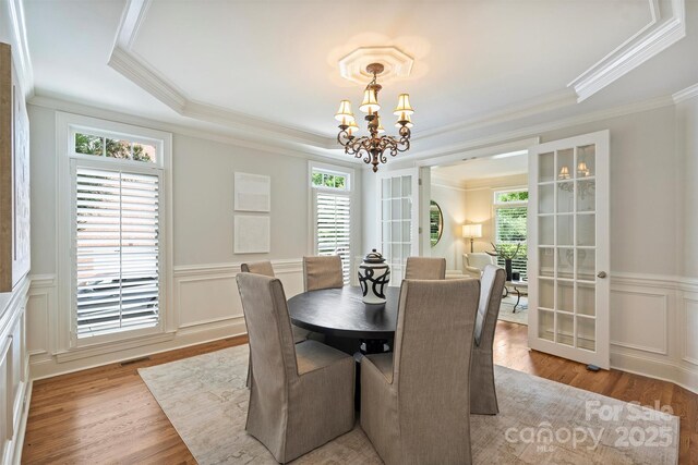 7319 Stonehaven Dr, Waxhaw, NC 28173 - dining area with a chandelier, crown molding, healthy amount of natural light, wood finished floors, and a decorative wall