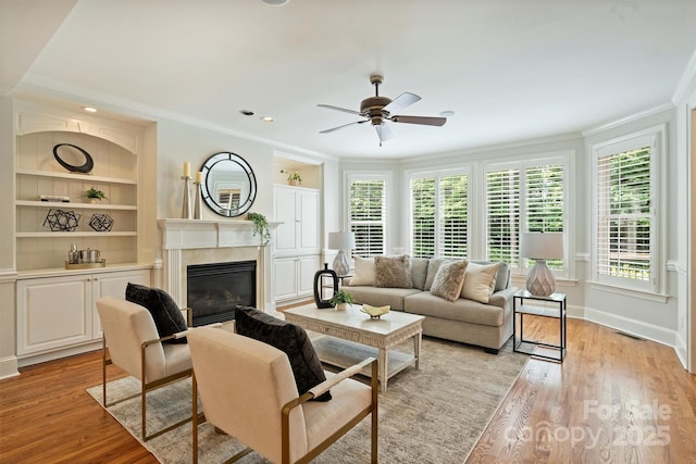 7319 Stonehaven Dr, Waxhaw, NC 28173 - living area with crown molding, a high end fireplace, ceiling fan, light wood-type flooring, and built in features