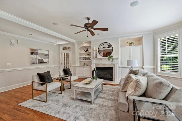 7319 Stonehaven Dr, Waxhaw, NC 28173 - living room with healthy amount of natural light, ceiling fan, crown molding, built in shelves, and wood finished floors
