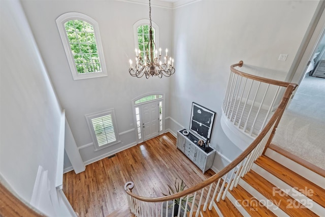 7319 Stonehaven Dr, Waxhaw, NC 28173 - foyer featuring a chandelier, stairway, wood finished floors, baseboards, and a towering ceiling