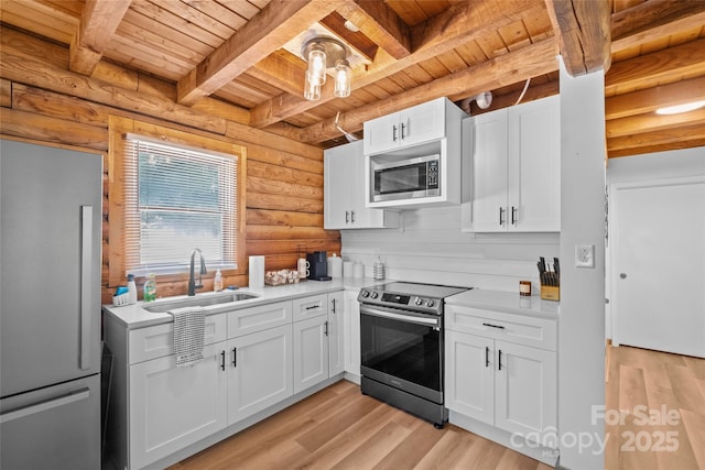 214 Mckenzie Way, Old Fort, NC 28762 - kitchen with stainless steel appliances, a sink, wood ceiling with exposed beams, rustic walls, and light countertops