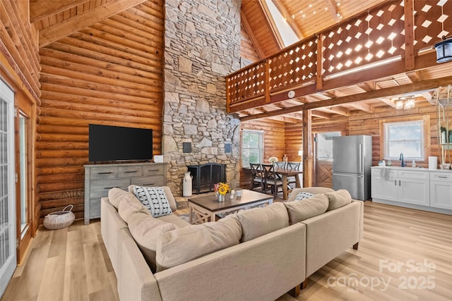 214 Mckenzie Way, Old Fort, NC 28762 - living area featuring log walls, wood ceiling with exposed beams, light wood finished floors, high vaulted ceiling, and a fireplace