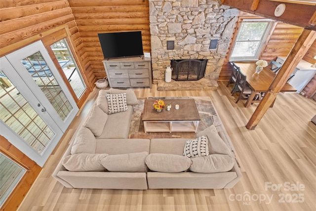 214 Mckenzie Way, Old Fort, NC 28762 - living area with rustic walls, wood finished floors, a stone fireplace, and healthy amount of natural light