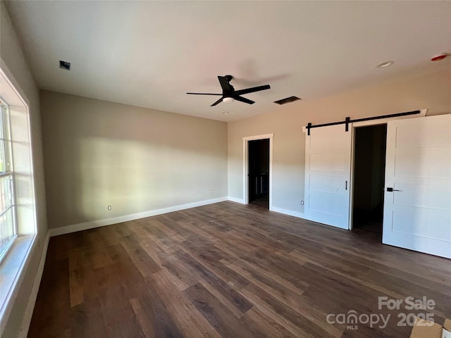 3000 Paul Payne Store Rd, Taylorsville, NC 28681 - unfurnished bedroom featuring a barn door, dark wood-type flooring, and ceiling fan