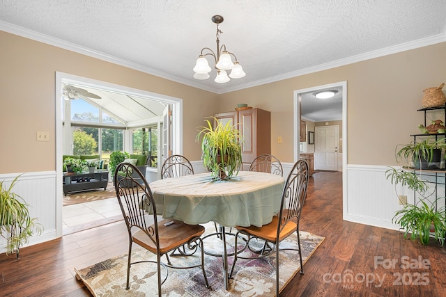 4026 Biggerstaff Rd, Maiden, NC 28650 - dining area featuring wood finished floors, a wainscoted wall, crown molding, a chandelier, and a textured ceiling