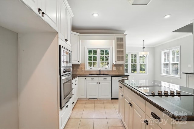 104 Fairwind Ct, Fort Mill, SC 29708 - kitchen featuring stainless steel appliances, dark countertops, light tile patterned floors, glass insert cabinets, and tasteful backsplash