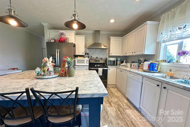 2449 Leonhardt Rd, Cherryville, NC 28021 - kitchen featuring appliances with stainless steel finishes, wall chimney exhaust hood, light countertops, crown molding, and light wood-type flooring