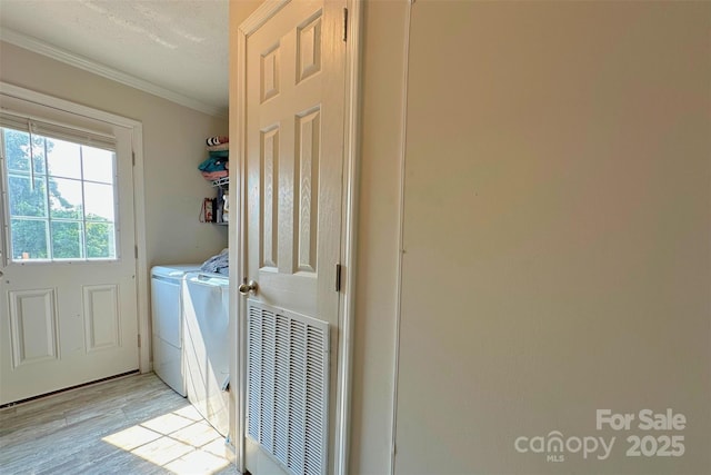2449 Leonhardt Rd, Cherryville, NC 28021 - laundry area featuring washing machine and clothes dryer, ornamental molding, and light wood-style floors