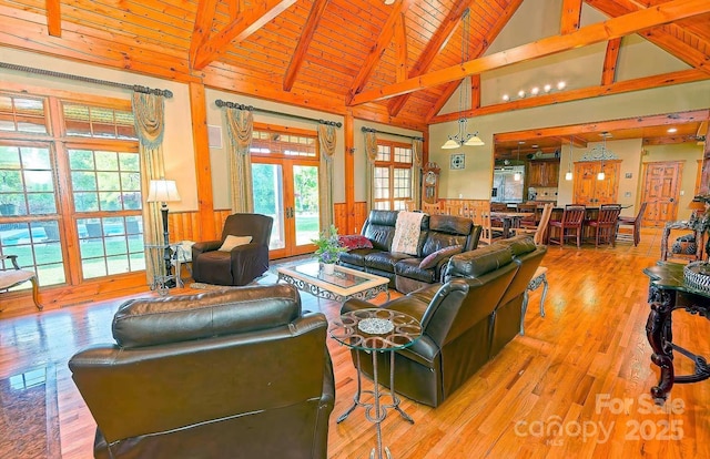 1250 Mountain Creek Rd, Rutherfordton, NC 28139 - living room with wood ceiling with exposed beams, wood finished floors, wainscoting, high vaulted ceiling, and french doors