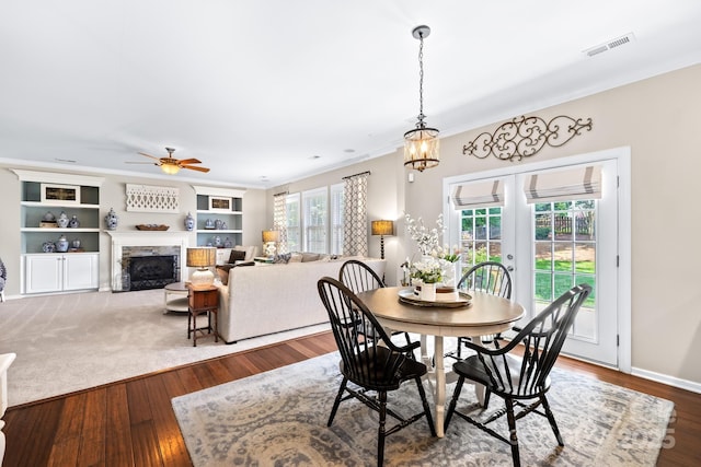 622 Lorain Ave NW, Concord, NC 28027 - dining room with french doors, a fireplace, a ceiling fan, wood finished floors, and crown molding