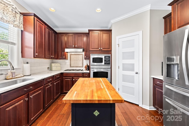 622 Lorain Ave NW, Concord, NC 28027 - kitchen with appliances with stainless steel finishes, butcher block countertops, crown molding, dark wood finished floors, and tasteful backsplash