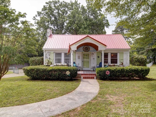 1614 Linwood Rd, Gaston, NC 28052 - view of front of house with a porch, a chimney, a front lawn, and metal roof