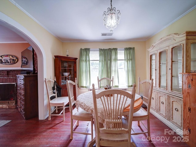 1614 Linwood Rd, Gaston, NC 28052 - dining space featuring dark wood-style flooring, crown molding, arched walkways, and a chandelier