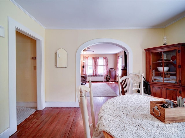 1614 Linwood Rd, Gaston, NC 28052 - dining room featuring radiator, arched walkways, wood finished floors, baseboards, and crown molding